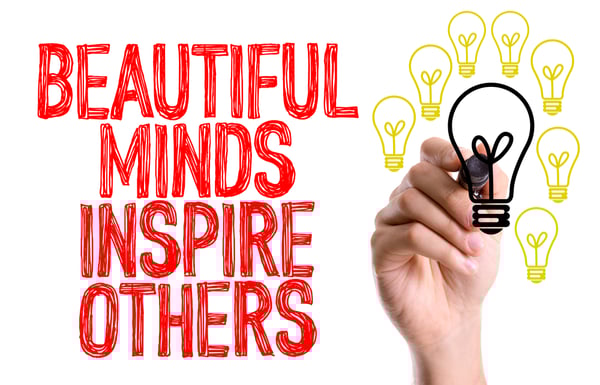 Hand with marker writing the word Beautiful Minds Inspire Others