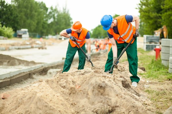 Image of construction workers digging on a road