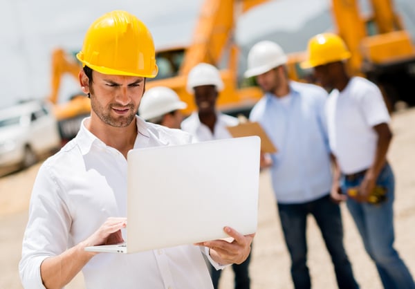 Male engineer at a construction site with a computer