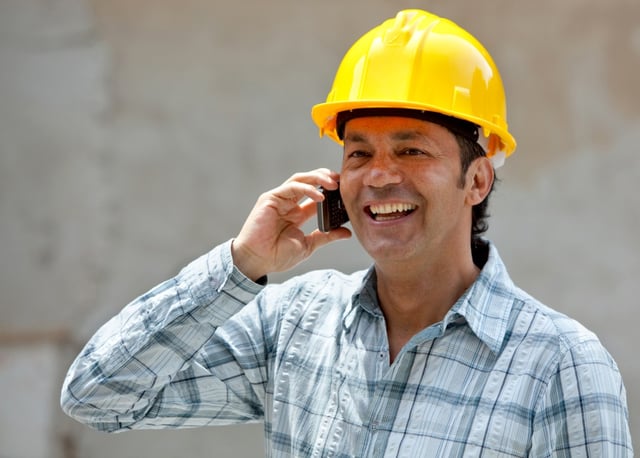 Construction worker talking on the phone at a building site.jpeg