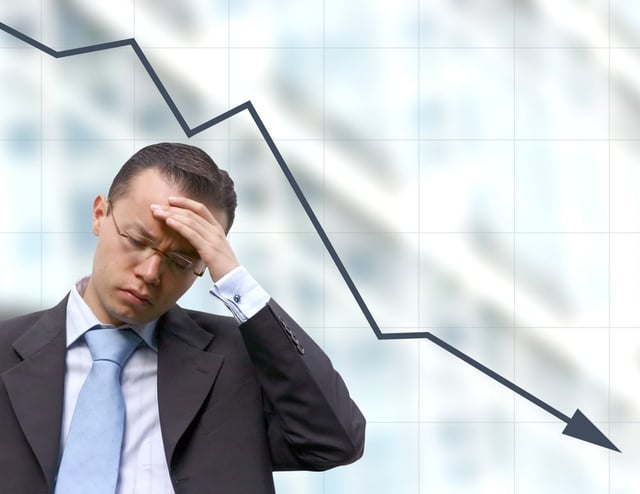 business man preocupied over a graph background.jpeg